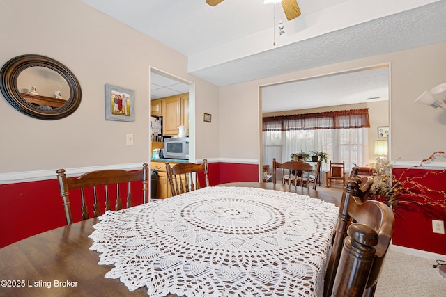 carpeted dining space featuring ceiling fan