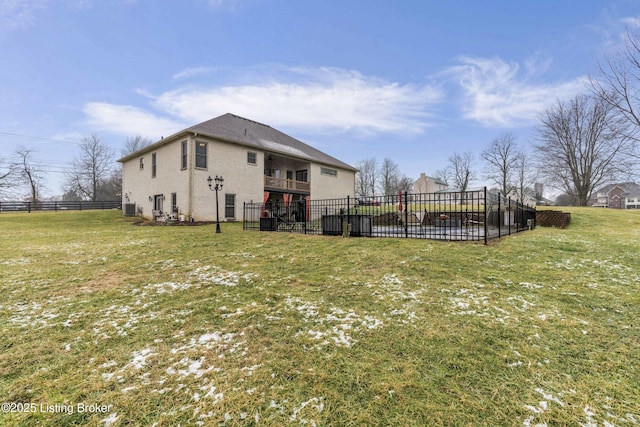 view of yard featuring a balcony, fence, and central AC