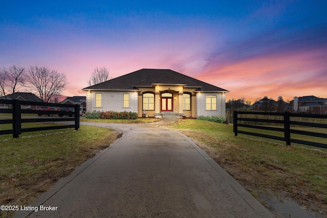 view of front of home with concrete driveway, a yard, and fence