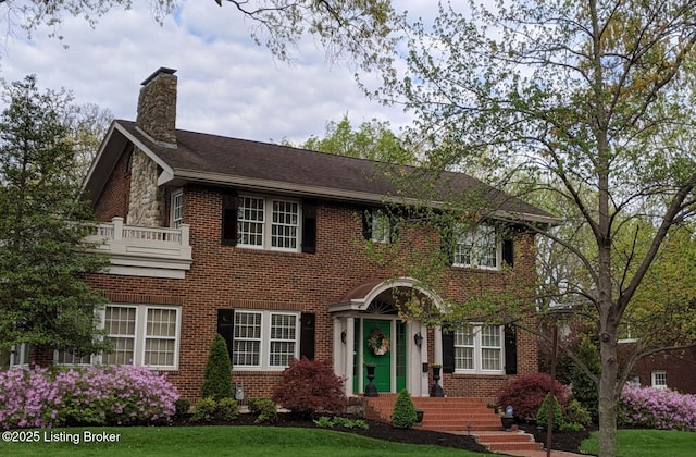 colonial inspired home featuring a front lawn