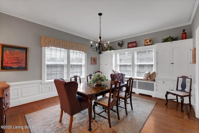 dining room featuring crown molding, dark hardwood / wood-style floors, radiator heating unit, and an inviting chandelier