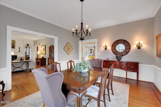 dining room featuring crown molding, a chandelier, and light hardwood / wood-style floors