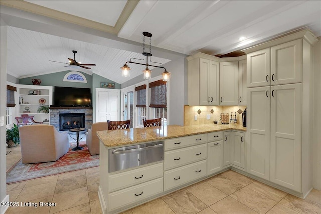 kitchen featuring vaulted ceiling with beams, decorative light fixtures, kitchen peninsula, a fireplace, and decorative backsplash