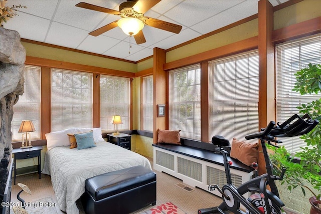 bedroom featuring multiple windows, radiator heating unit, a paneled ceiling, and ceiling fan