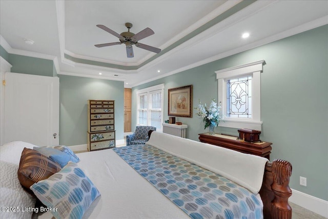 carpeted bedroom with ceiling fan, ornamental molding, and a tray ceiling