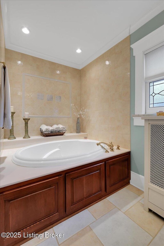 bathroom featuring a washtub, tile patterned floors, ornamental molding, and tile walls