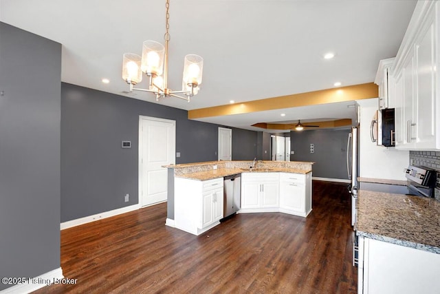 kitchen featuring dark wood-style flooring, white cabinetry, baseboards, appliances with stainless steel finishes, and decorative backsplash