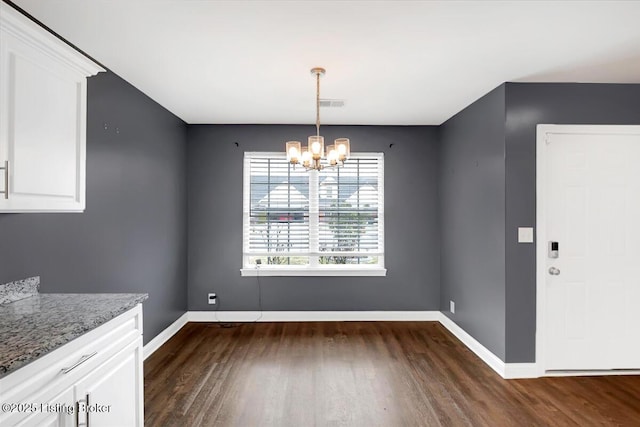 unfurnished dining area with baseboards, visible vents, a chandelier, and dark wood-style flooring