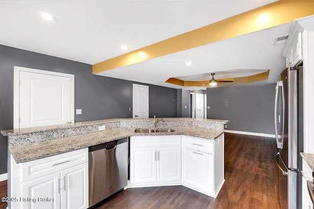 kitchen featuring appliances with stainless steel finishes, dark wood-style flooring, a sink, and white cabinets