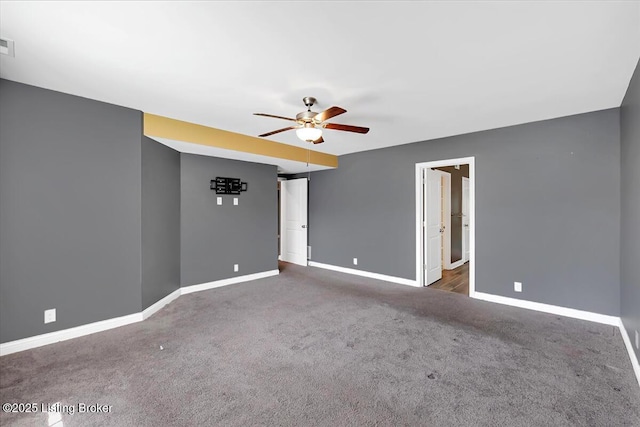 carpeted empty room with visible vents, baseboards, and a ceiling fan