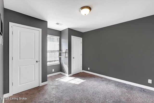 unfurnished bedroom featuring carpet, visible vents, and baseboards