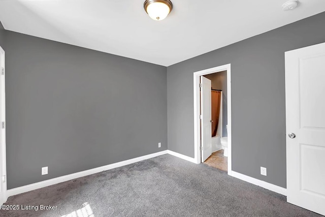 unfurnished bedroom featuring carpet, connected bathroom, and baseboards