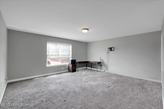 carpeted spare room featuring baseboards