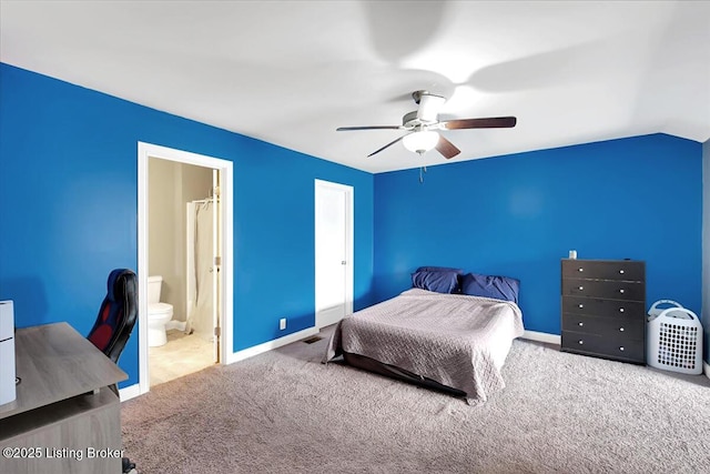 carpeted bedroom featuring lofted ceiling, visible vents, a ceiling fan, baseboards, and ensuite bath