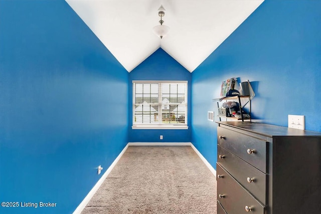 interior space featuring lofted ceiling, carpet flooring, visible vents, and baseboards