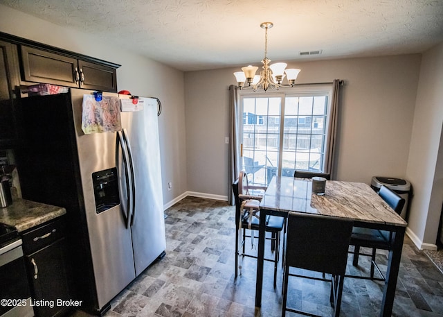 kitchen with an inviting chandelier, dark brown cabinets, stainless steel refrigerator with ice dispenser, a textured ceiling, and decorative light fixtures