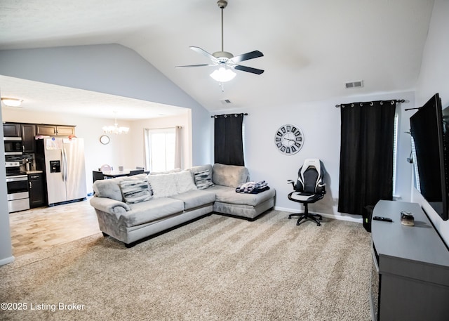 living room featuring ceiling fan with notable chandelier, lofted ceiling, and light colored carpet