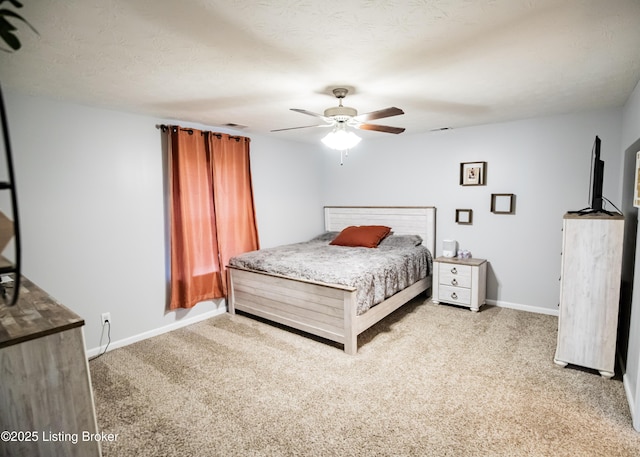 carpeted bedroom featuring ceiling fan and a textured ceiling