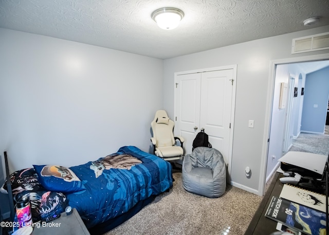 bedroom with a closet, carpet, and a textured ceiling