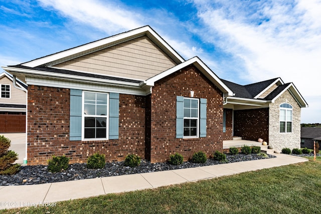 view of home's exterior featuring brick siding and a lawn