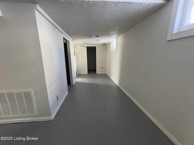 hallway with concrete flooring and a textured ceiling