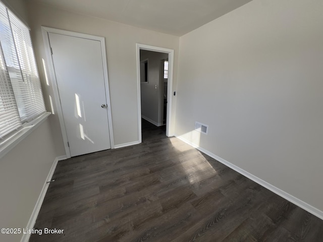 unfurnished bedroom with dark hardwood / wood-style flooring