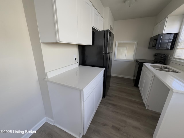 kitchen featuring white cabinets, sink, light hardwood / wood-style flooring, and black appliances