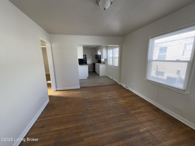 unfurnished living room with dark wood-type flooring