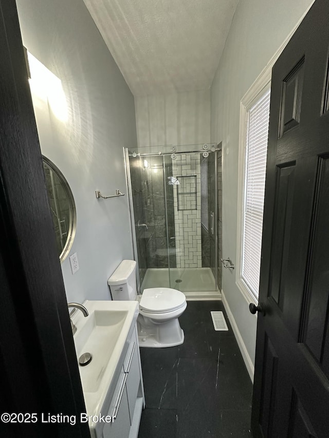 full bathroom featuring toilet, a shower stall, baseboards, and vanity