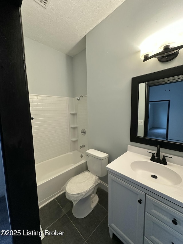 bathroom with a textured ceiling, bathtub / shower combination, toilet, vanity, and tile patterned floors