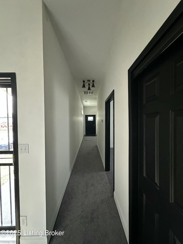 corridor featuring carpet, visible vents, and baseboards