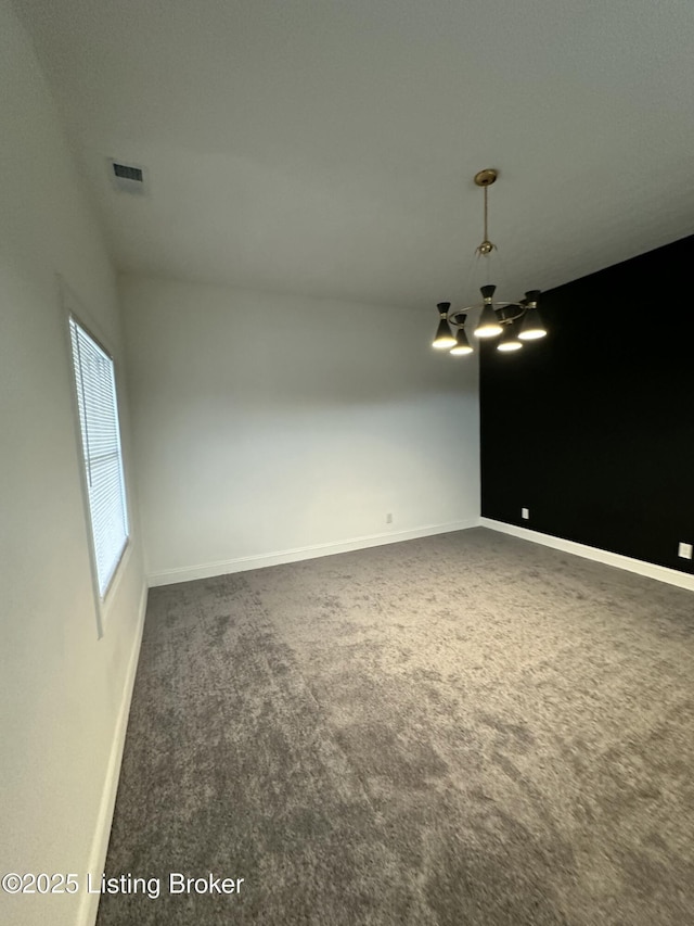 carpeted spare room featuring visible vents and baseboards