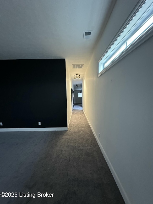 hall featuring carpet, visible vents, and baseboards