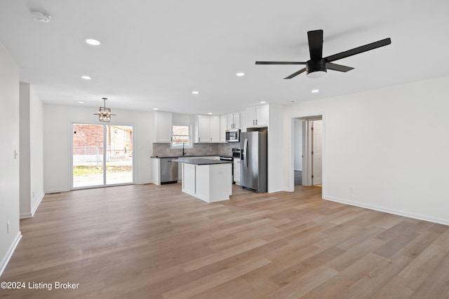 kitchen with pendant lighting, white cabinetry, decorative backsplash, a center island, and stainless steel appliances