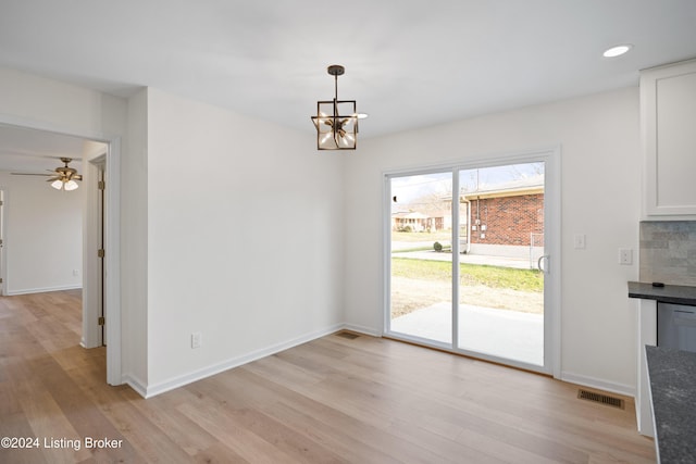 unfurnished dining area featuring light hardwood / wood-style flooring and a chandelier