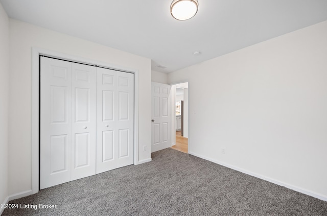 unfurnished bedroom with carpet flooring and a closet