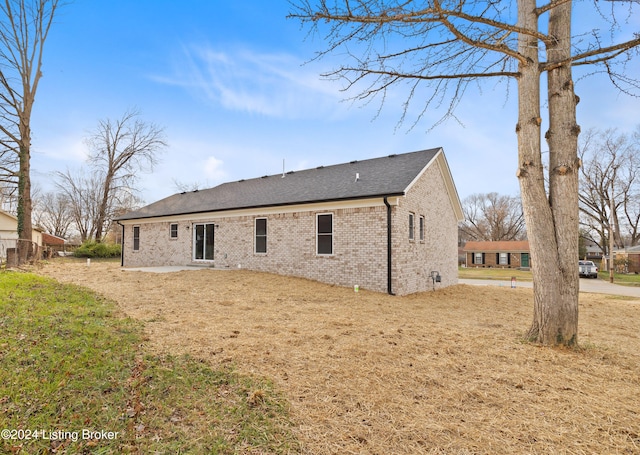 back of property featuring a patio and a yard