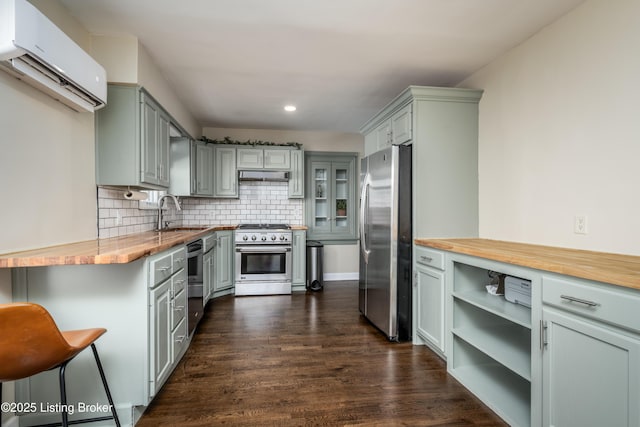 kitchen featuring sink, wooden counters, backsplash, stainless steel appliances, and an AC wall unit