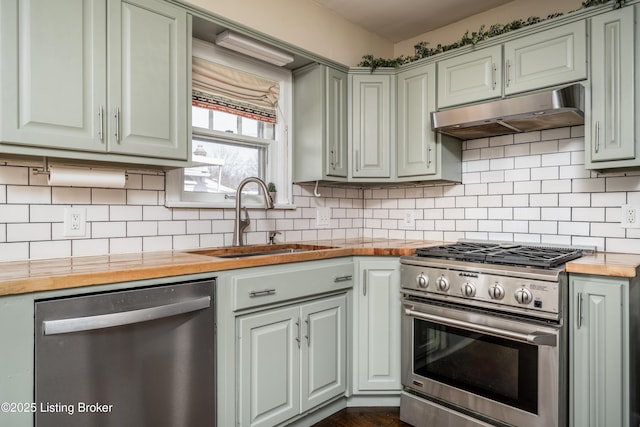 kitchen with butcher block countertops, decorative backsplash, sink, and appliances with stainless steel finishes