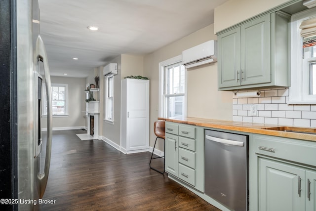 kitchen with butcher block countertops, backsplash, an AC wall unit, and appliances with stainless steel finishes