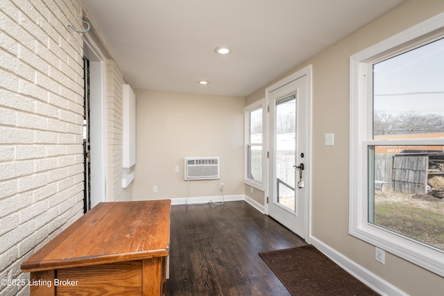 doorway to outside featuring brick wall, dark hardwood / wood-style floors, and a wall mounted AC