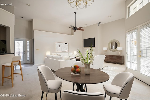 carpeted dining space with a wealth of natural light, french doors, and a high ceiling