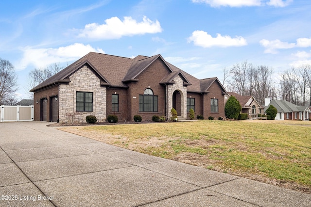 french provincial home with a front lawn and a garage