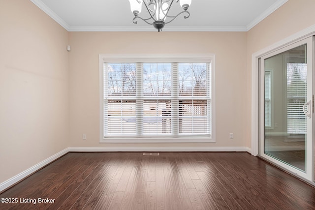 spare room featuring dark hardwood / wood-style flooring, crown molding, and an inviting chandelier