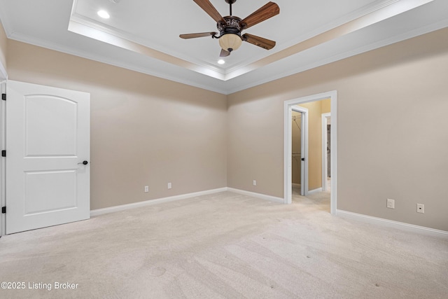 unfurnished room featuring ceiling fan, crown molding, a raised ceiling, and light colored carpet