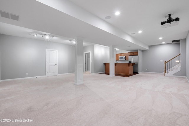 basement featuring light colored carpet and stainless steel fridge with ice dispenser