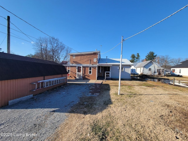 back of house featuring a lawn