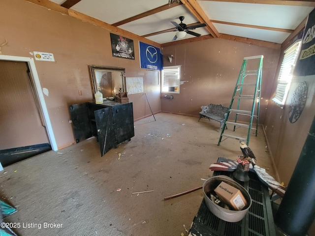 unfurnished living room with ceiling fan and vaulted ceiling with beams