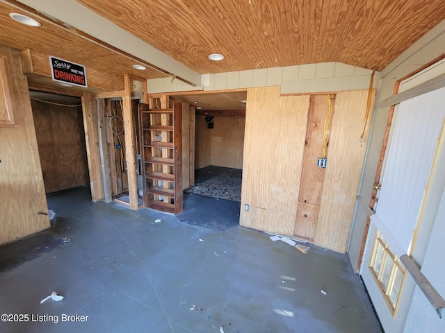 unfurnished room with wood ceiling and wood walls