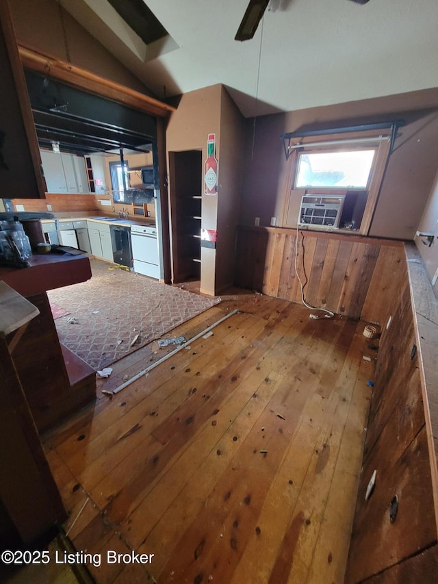 kitchen with lofted ceiling, hardwood / wood-style flooring, ceiling fan, dishwasher, and cooling unit